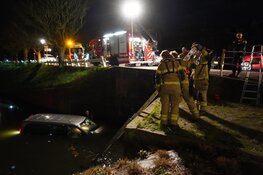 Bestelbus te water in Enkhuizen, bestuurder klimt op dak voertuig
