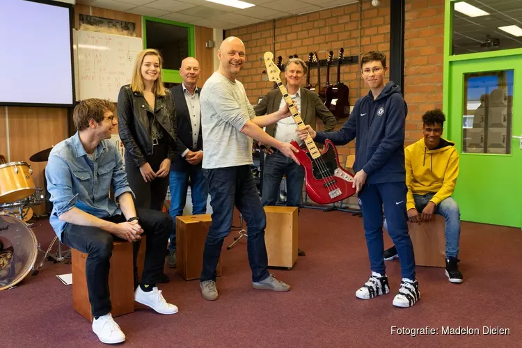 Ouders Robin schenken basgitaar aan het muzieklokaal van de RSG Enkhuizen